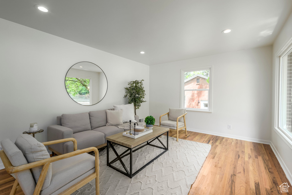 Living area with light wood finished floors, healthy amount of natural light, recessed lighting, and baseboards