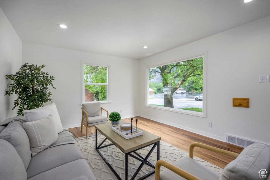 Living area with baseboards, recessed lighting, and light wood-style floors