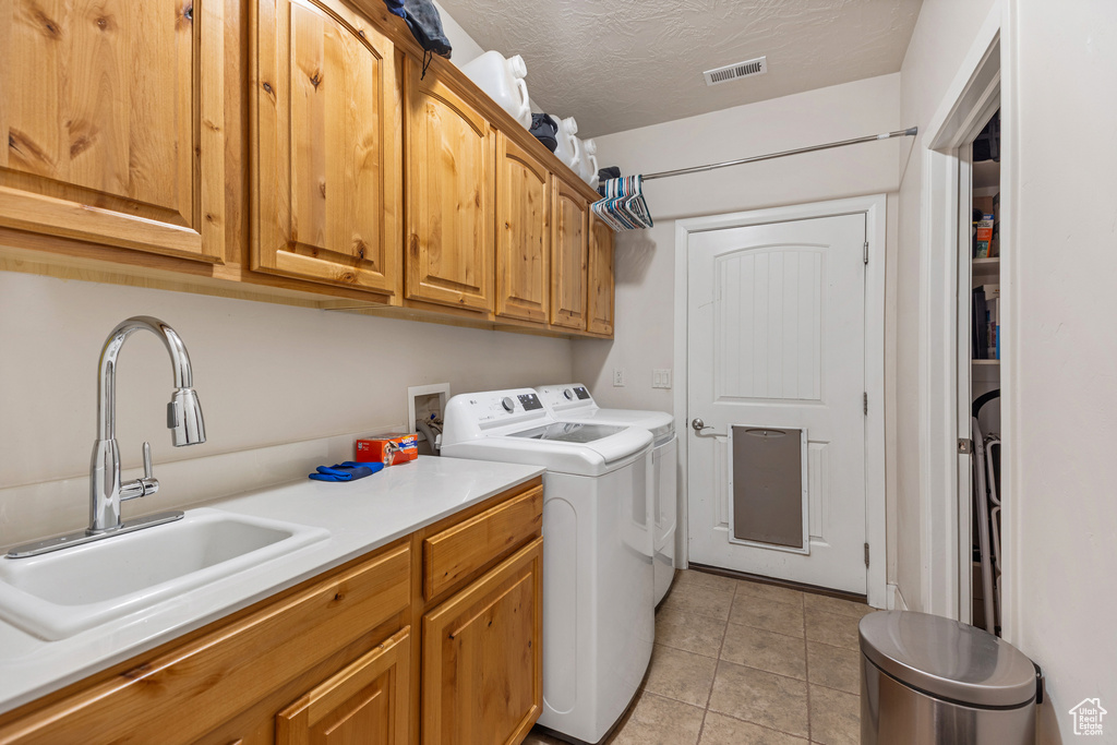 Laundry area featuring cabinet space, washer and clothes dryer, and light tile patterned floors