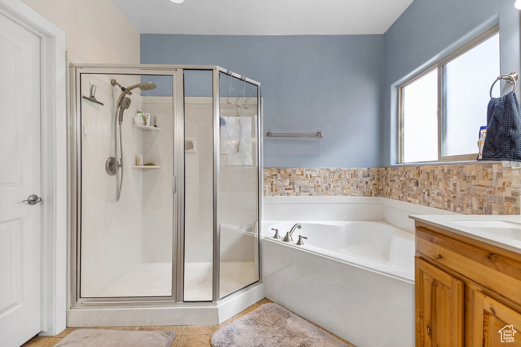 Full bathroom with a shower stall, a bath, tile patterned floors, and vanity
