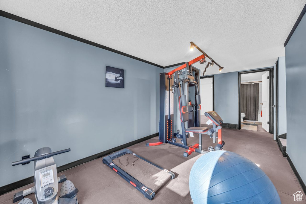 Exercise room featuring baseboards and a textured ceiling