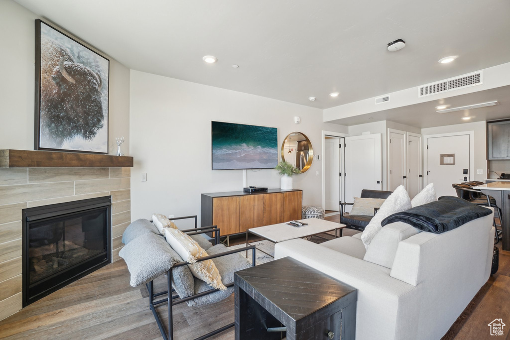 Living area with wood finished floors, recessed lighting, and a tile fireplace