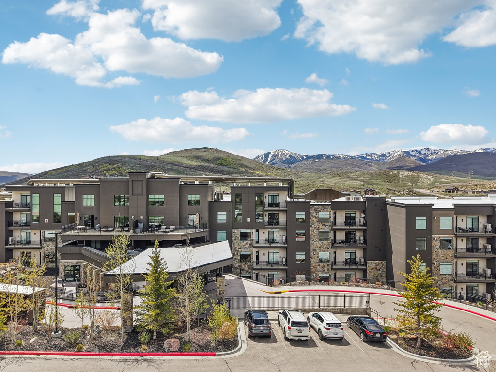 View of apartment building / complex featuring a mountain view and uncovered parking
