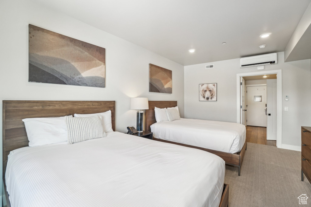 Bedroom featuring a wall mounted AC, recessed lighting, and baseboards