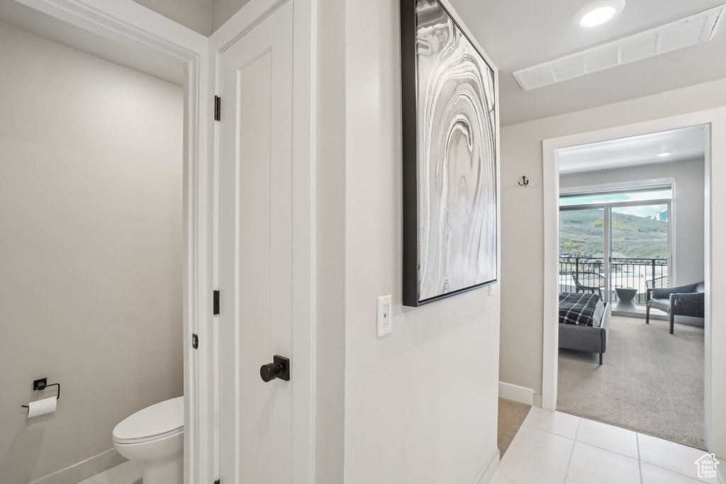 Bathroom featuring baseboards, toilet, and tile patterned flooring