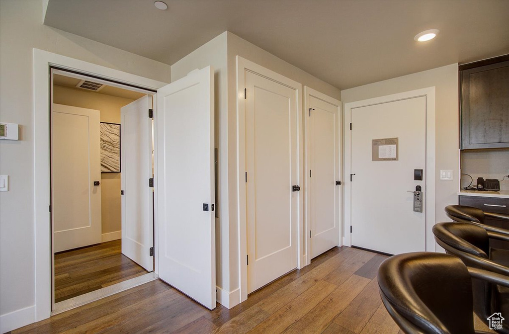 Corridor featuring wood finished floors, recessed lighting, and baseboards