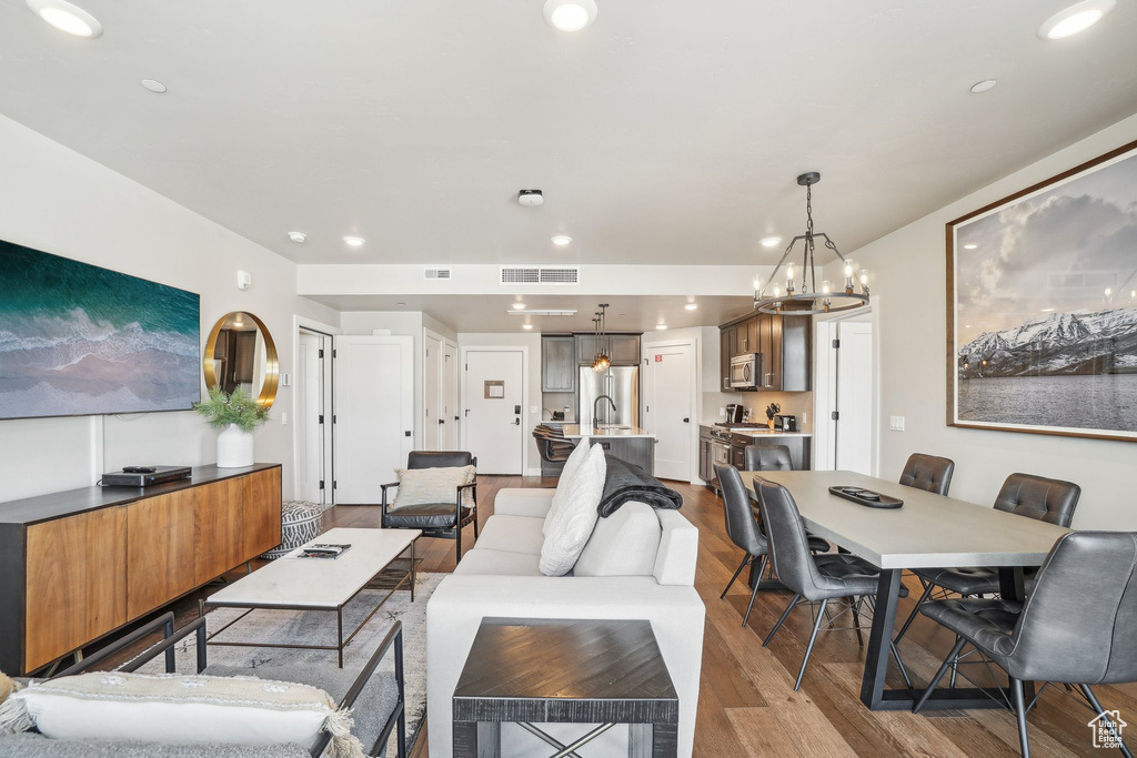 Living room with wood finished floors, recessed lighting, and a chandelier