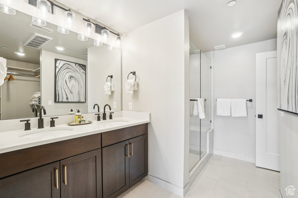 Bathroom with tile patterned flooring, a shower stall, double vanity, baseboards, and recessed lighting