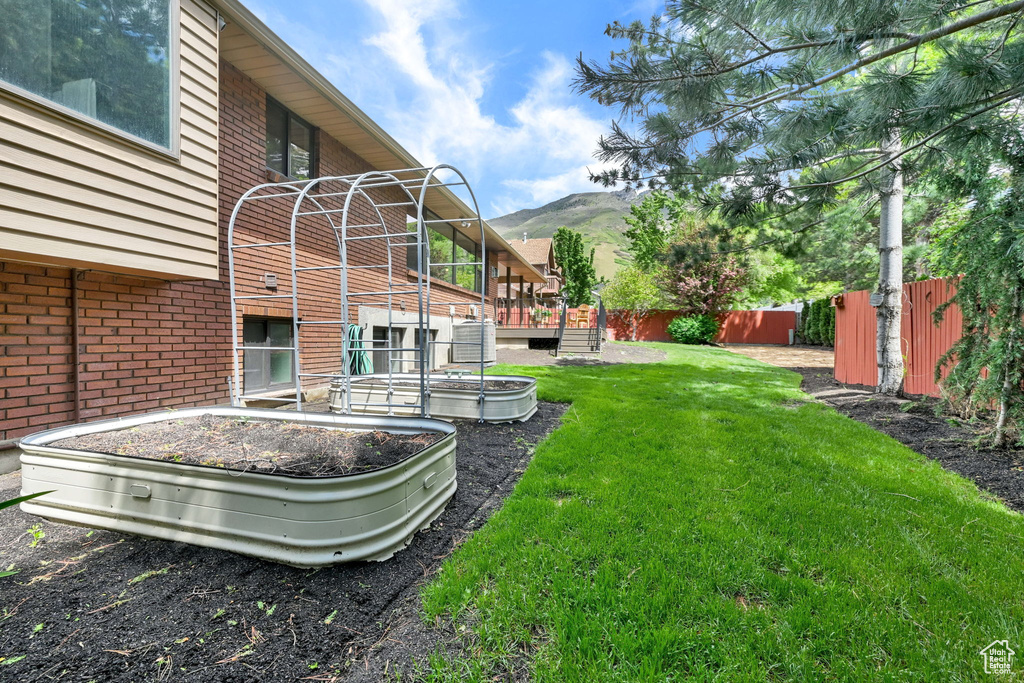 View of yard with a deck with mountain view