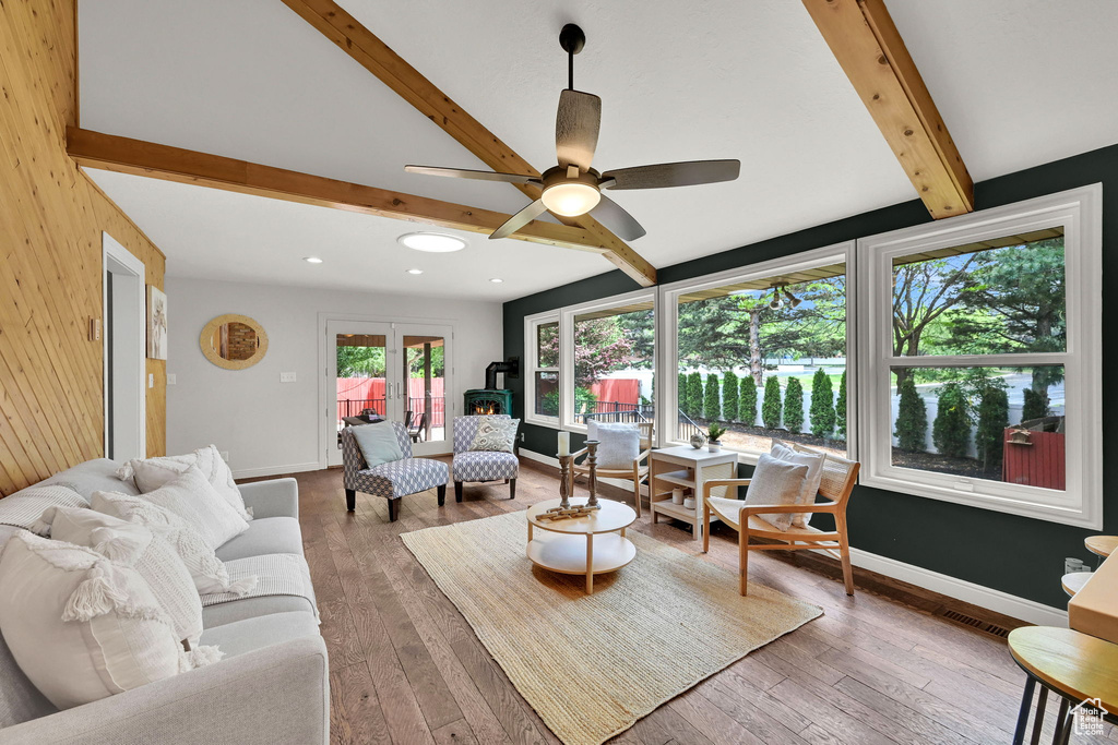 Living area featuring beam ceiling, a ceiling fan, hardwood / wood-style flooring, recessed lighting, and baseboards