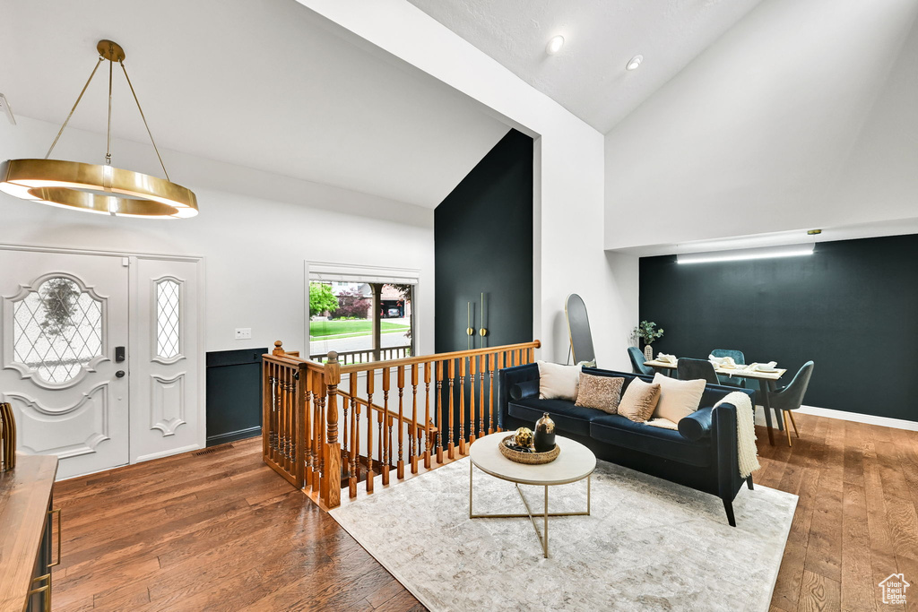 Living room featuring high vaulted ceiling, hardwood / wood-style floors, baseboards, and recessed lighting
