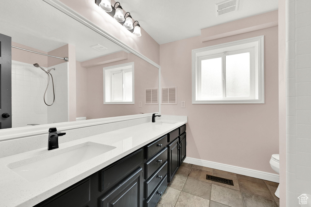 Bathroom with toilet, healthy amount of natural light, and baseboards