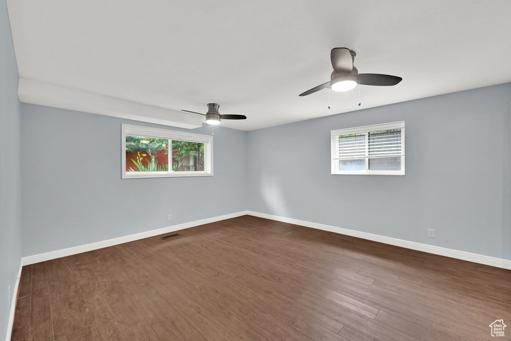 Empty room with plenty of natural light, dark wood finished floors, and baseboards