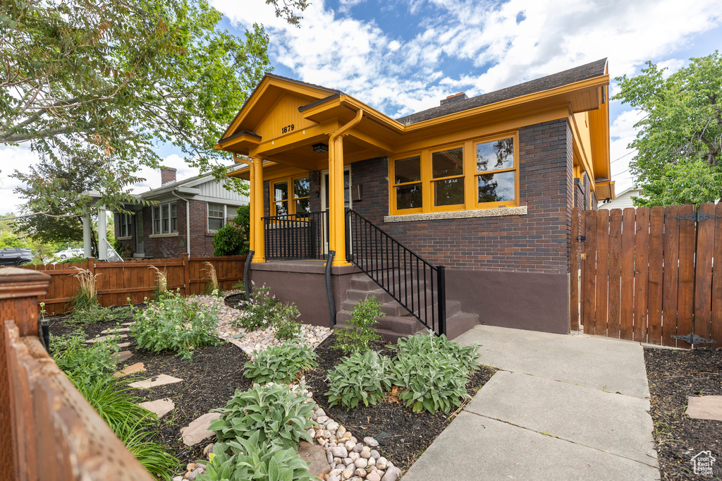 View of front of property with brick siding and fence