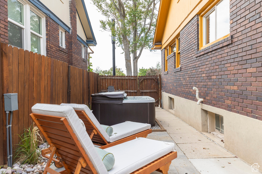 View of patio with a hot tub and a fenced backyard