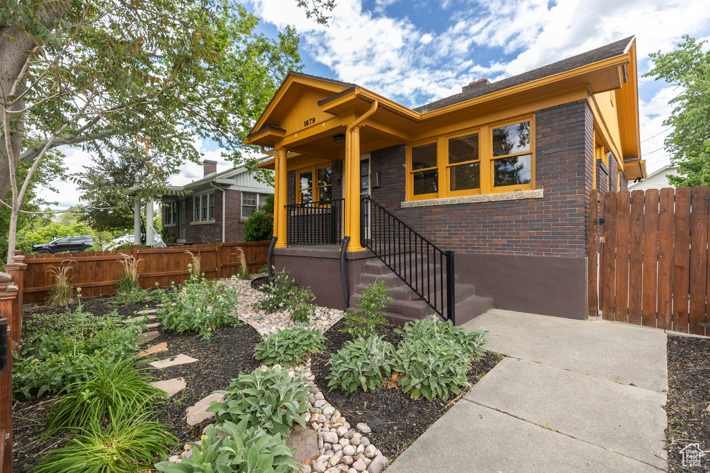 View of front of house featuring brick siding and fence
