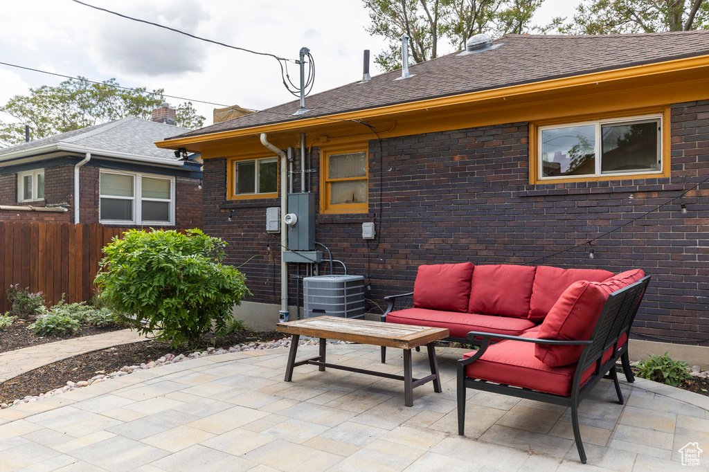 View of patio / terrace featuring an outdoor living space, fence, and central AC