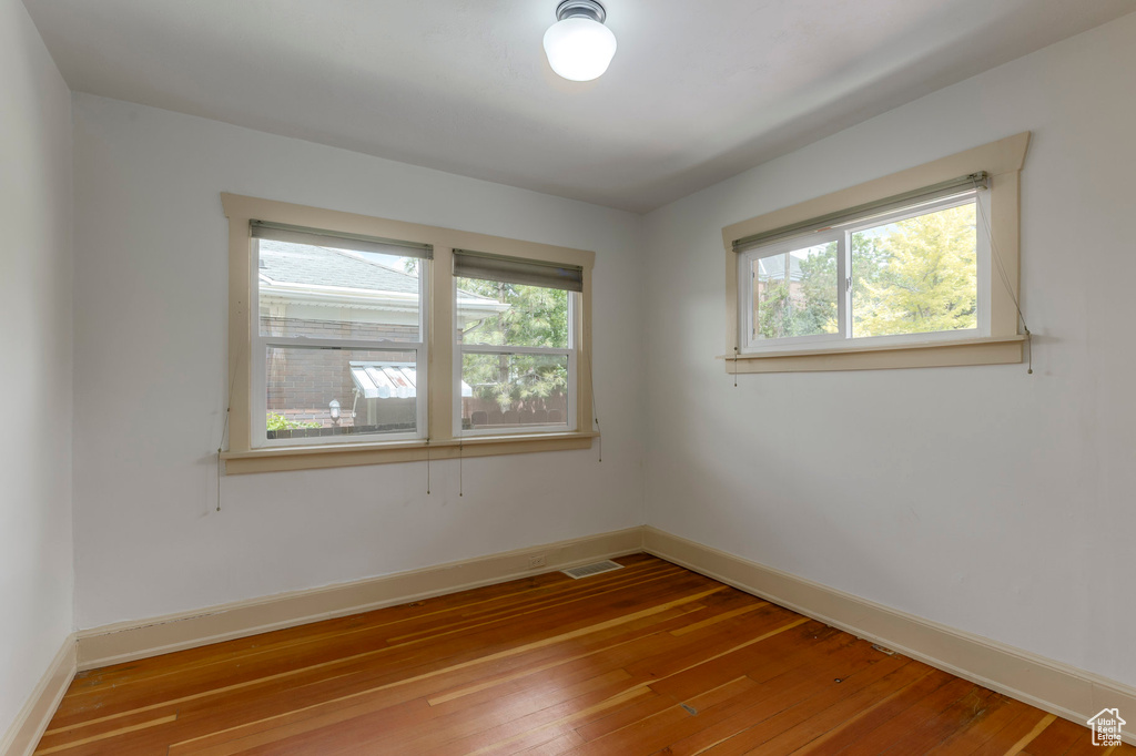 Spare room with plenty of natural light, hardwood / wood-style flooring, and baseboards