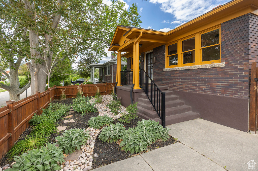 Property entrance with fence and brick siding