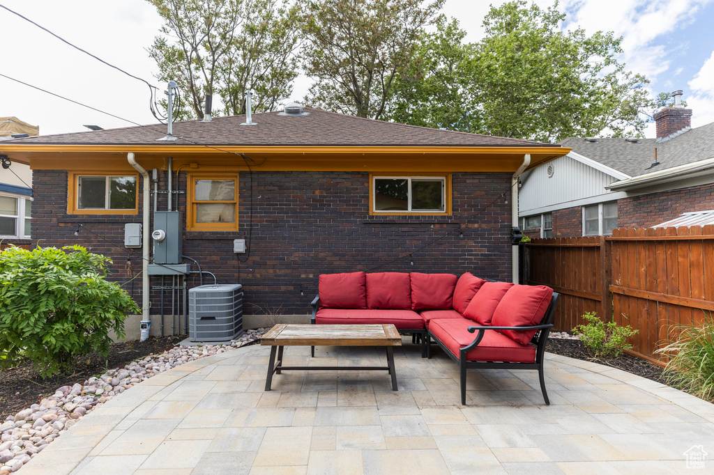 View of patio / terrace with an outdoor living space, central air condition unit, and fence