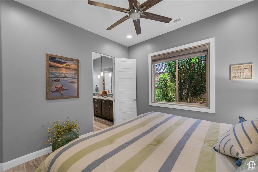 Bedroom with light wood finished floors, baseboards, connected bathroom, recessed lighting, and ceiling fan