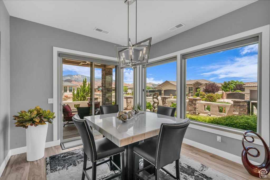 Dining room with a chandelier, baseboards, and light wood-style floors