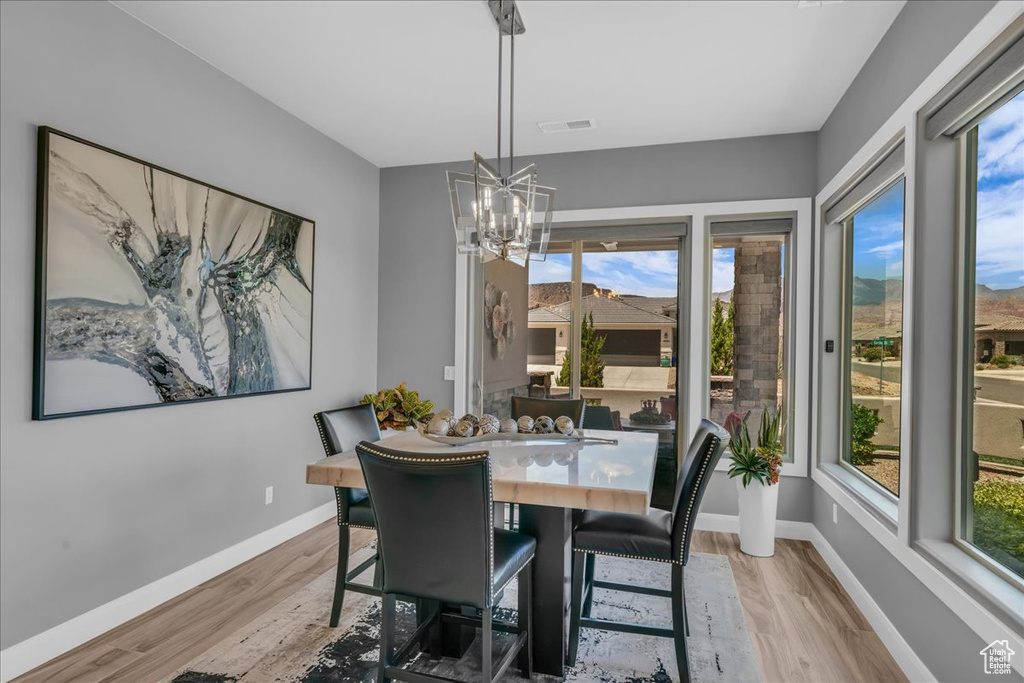 Dining room with a chandelier, baseboards, and light wood finished floors