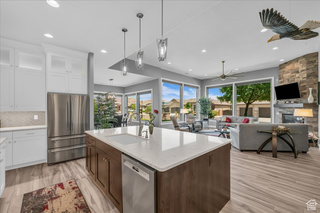 Kitchen with stainless steel appliances, a sink, recessed lighting, white cabinetry, and pendant lighting