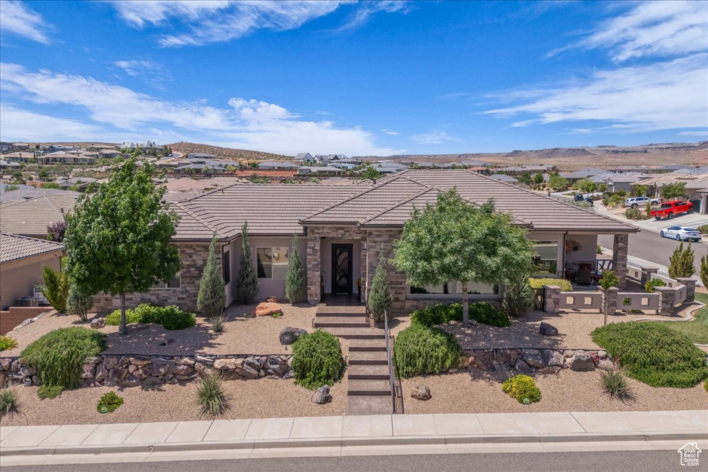 View of front facade featuring a tile roof, a mountain view, and stucco siding