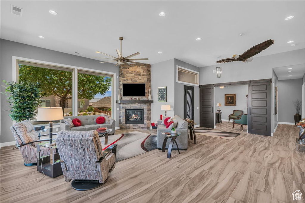 Living area featuring recessed lighting, baseboards, a fireplace, a ceiling fan, and wood finished floors