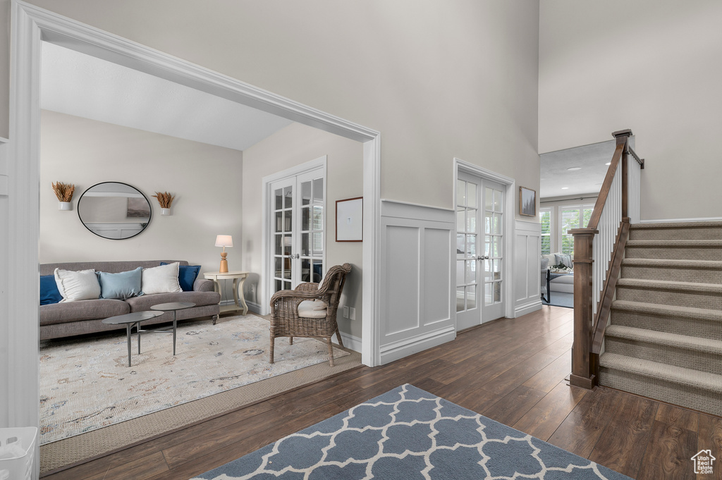 Entrance foyer featuring french doors, hardwood / wood-style floors, stairs, and a wainscoted wall