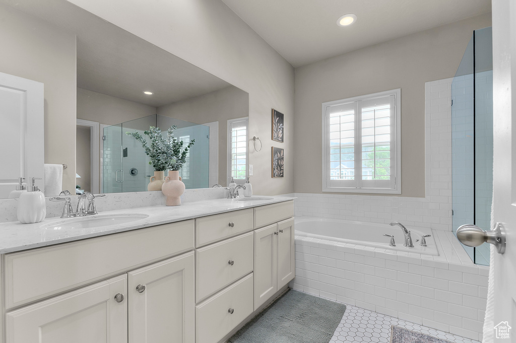 Bathroom with a stall shower, a garden tub, double vanity, tile patterned flooring, and recessed lighting