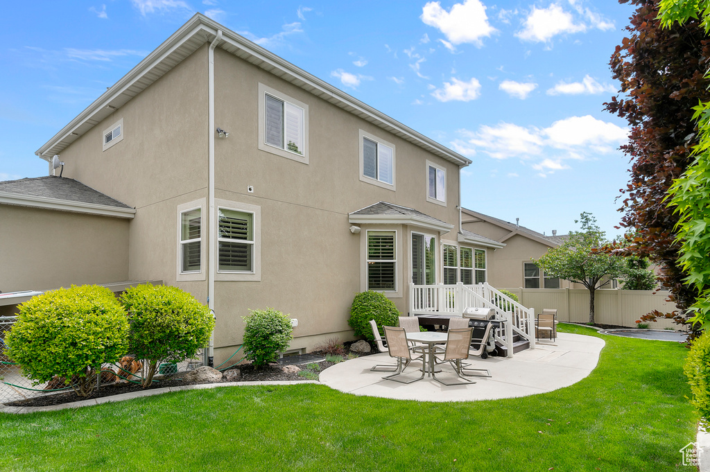 Rear view of property with stucco siding and a patio area