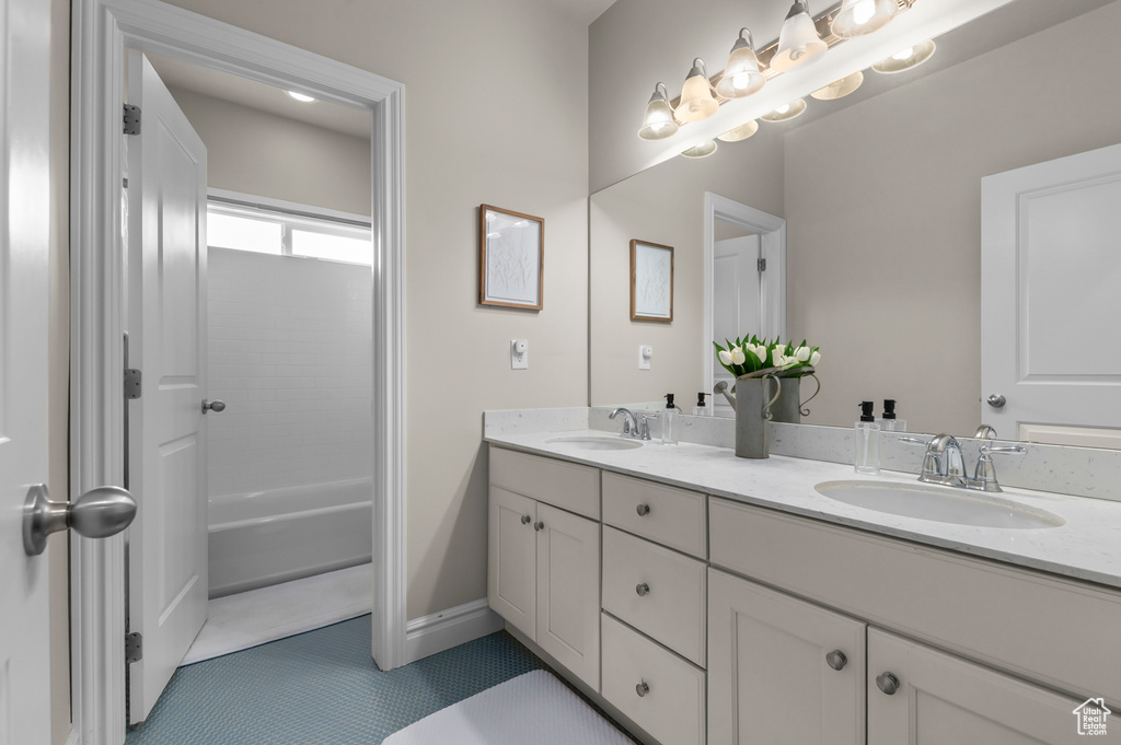 Full bathroom featuring double vanity, tile patterned floors, and baseboards