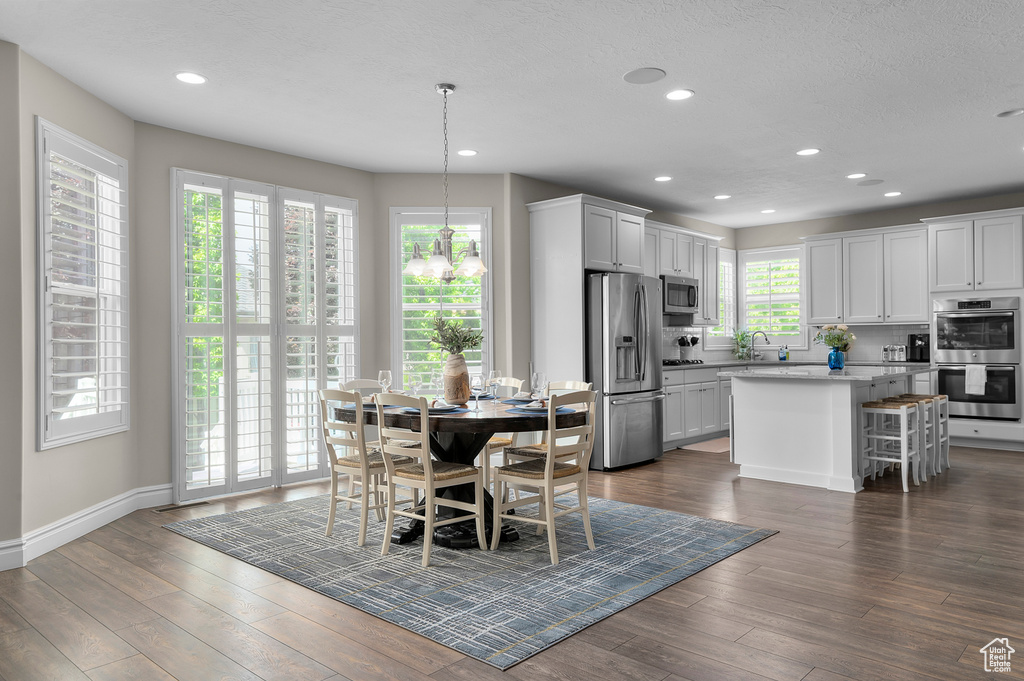 Dining area with recessed lighting, dark wood-style flooring, and baseboards