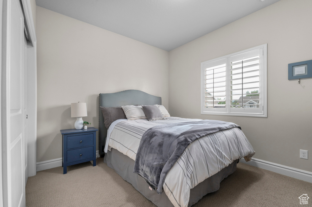 Bedroom featuring light carpet and baseboards