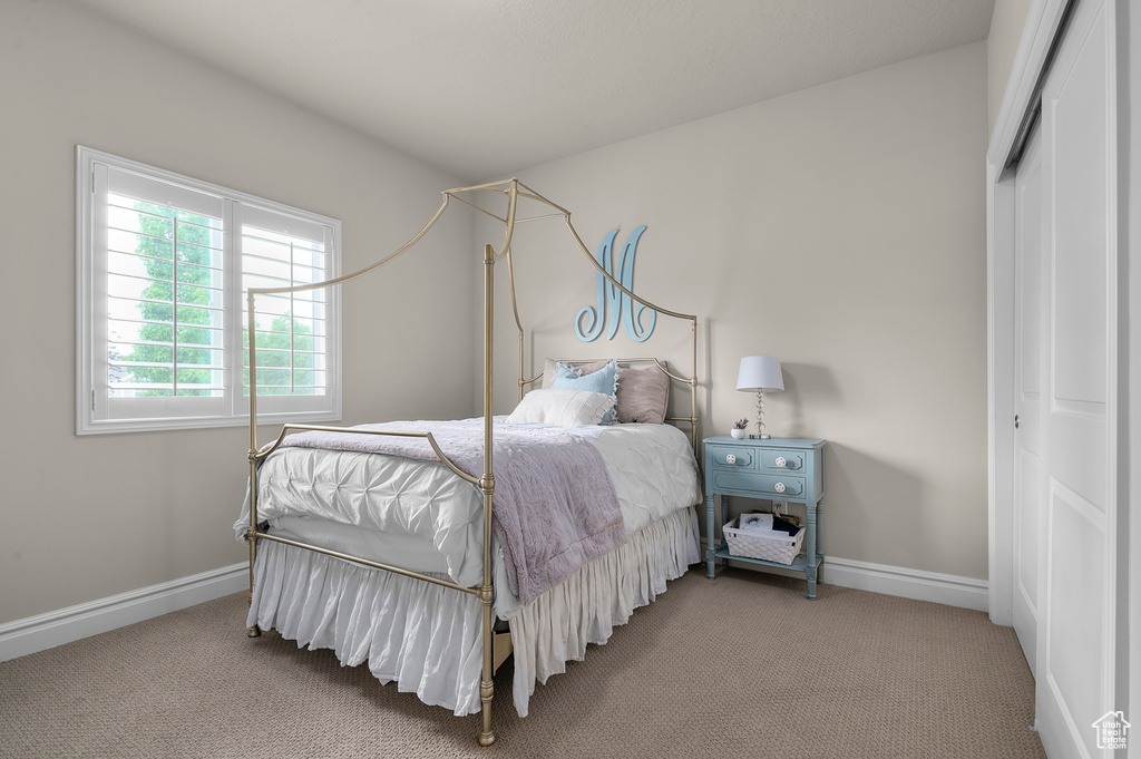 Bedroom featuring a closet, carpet, and baseboards
