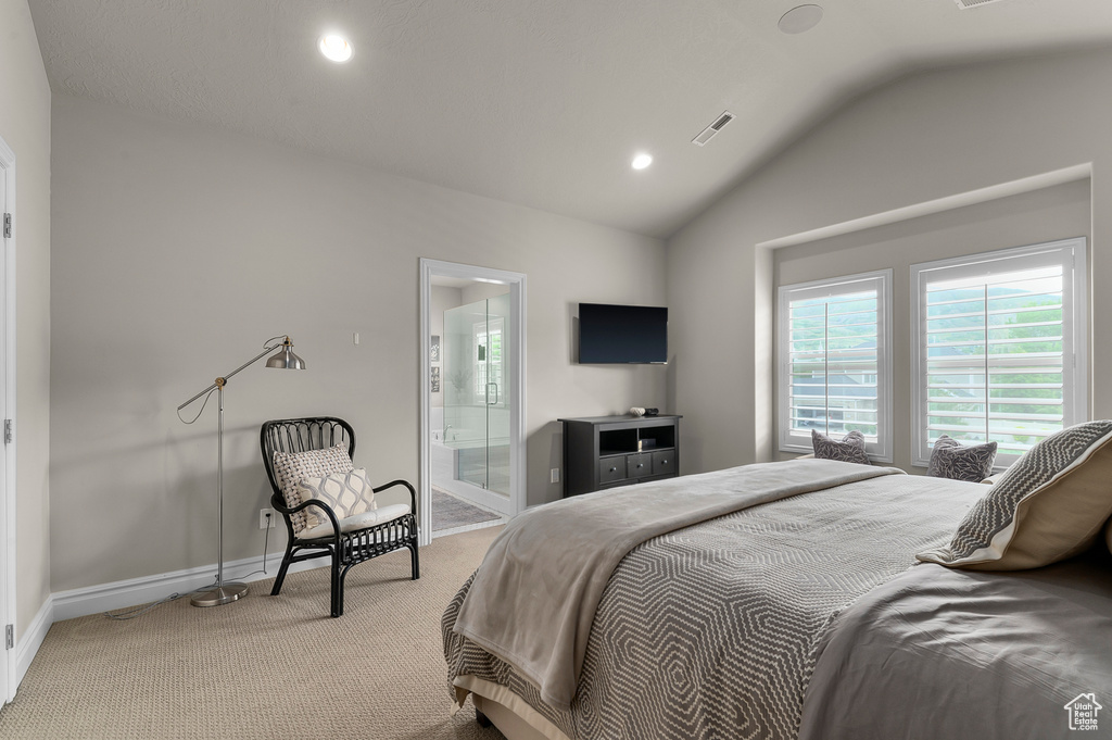 Carpeted bedroom with vaulted ceiling, baseboards, recessed lighting, and ensuite bathroom