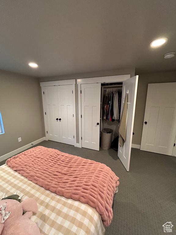 Bedroom with two closets, baseboards, recessed lighting, and dark carpet