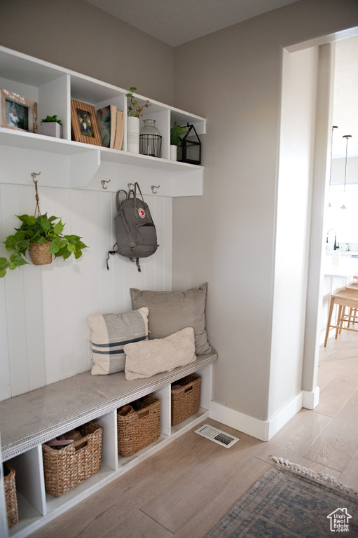 Mudroom with light wood finished floors and baseboards