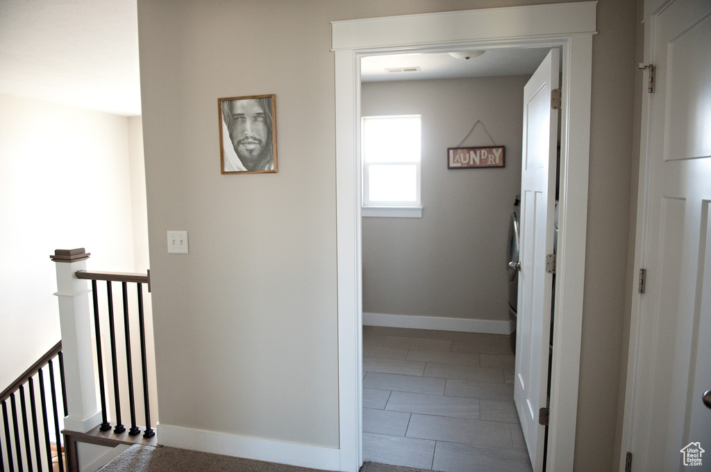 Hallway featuring an upstairs landing and baseboards
