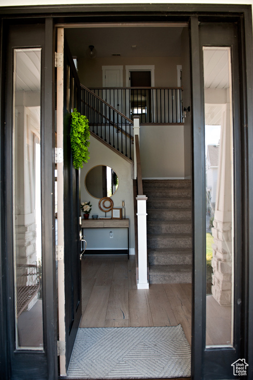 Foyer with wood finished floors, stairs, and baseboards