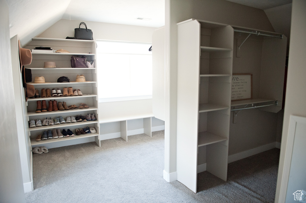 Spacious closet featuring carpet and vaulted ceiling