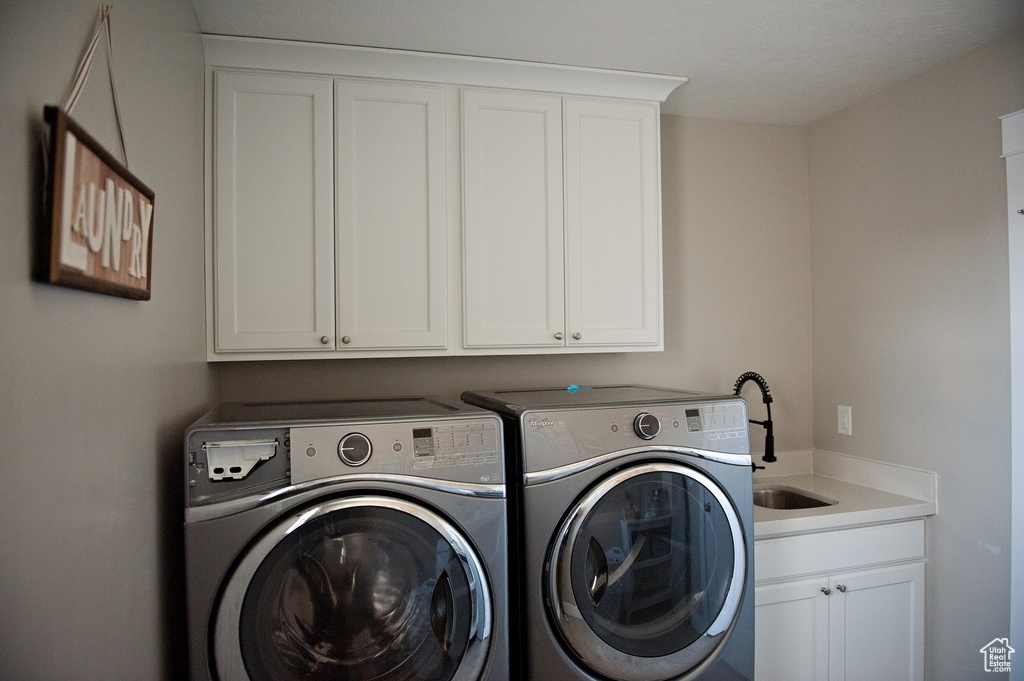 Washroom featuring cabinet space and washer and dryer
