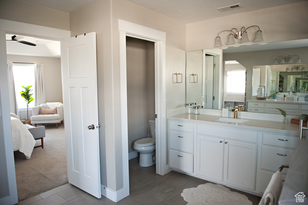 Bathroom featuring ensuite bathroom, healthy amount of natural light, toilet, and vanity