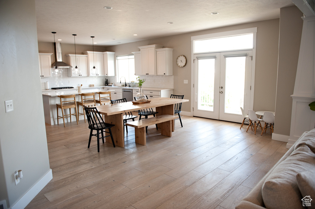 Dining area featuring baseboards, french doors, recessed lighting, and light wood finished floors