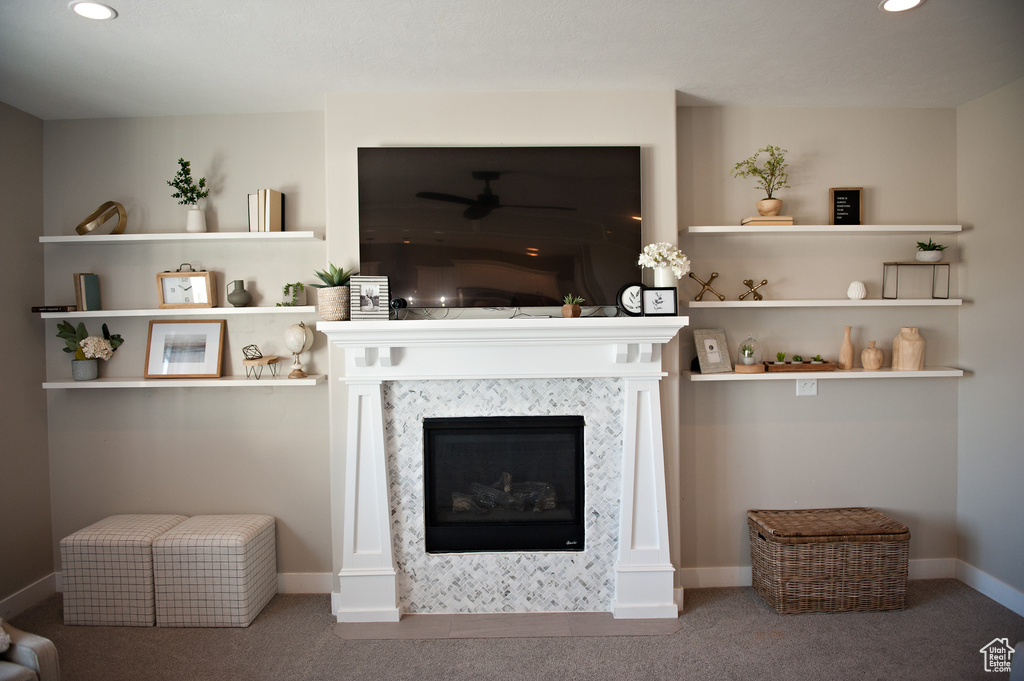 Carpeted living room featuring recessed lighting, a ceiling fan, a glass covered fireplace, and baseboards