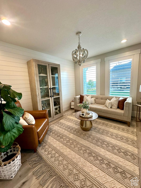 Living room featuring wood finished floors, a chandelier, and a textured ceiling