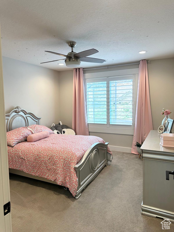 Bedroom with light colored carpet, a ceiling fan, baseboards, recessed lighting, and a textured ceiling
