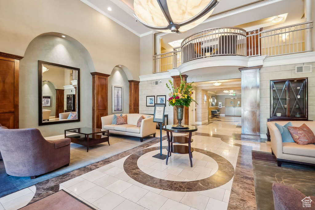 Lobby featuring a towering ceiling, ornamental molding, and recessed lighting